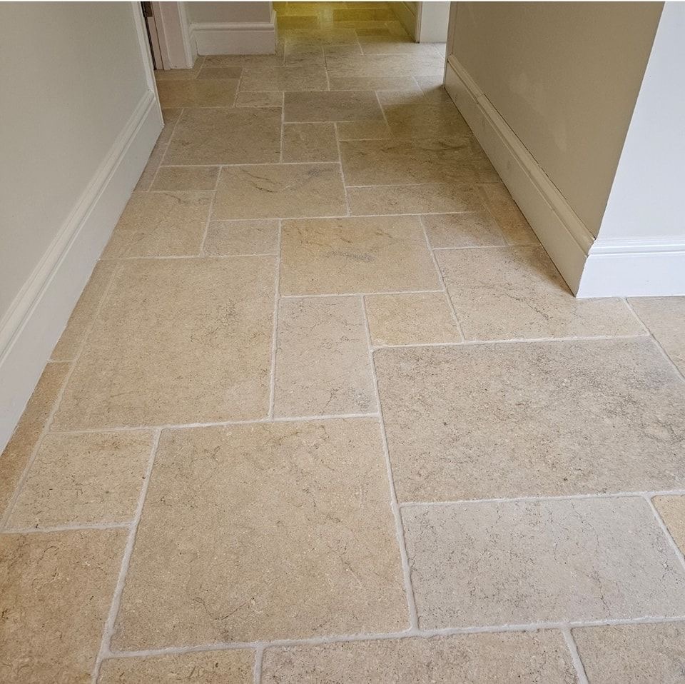 Light-colored natural stone hallway floor with large stone slabs in different sizes